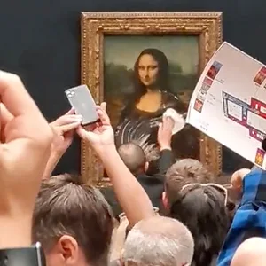 Ein Mitarbeiter des Louvre wischt den Sahnekuchen von der Vitrine, die die Mona Lisa im Louvre-Museum schützt.