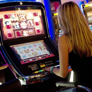 Eine Frau bedient einen Spielautomaten