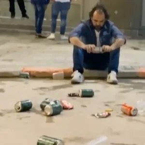 Real Fans sitzt vorm Stadion und guckt das Spiel auf dem Handy