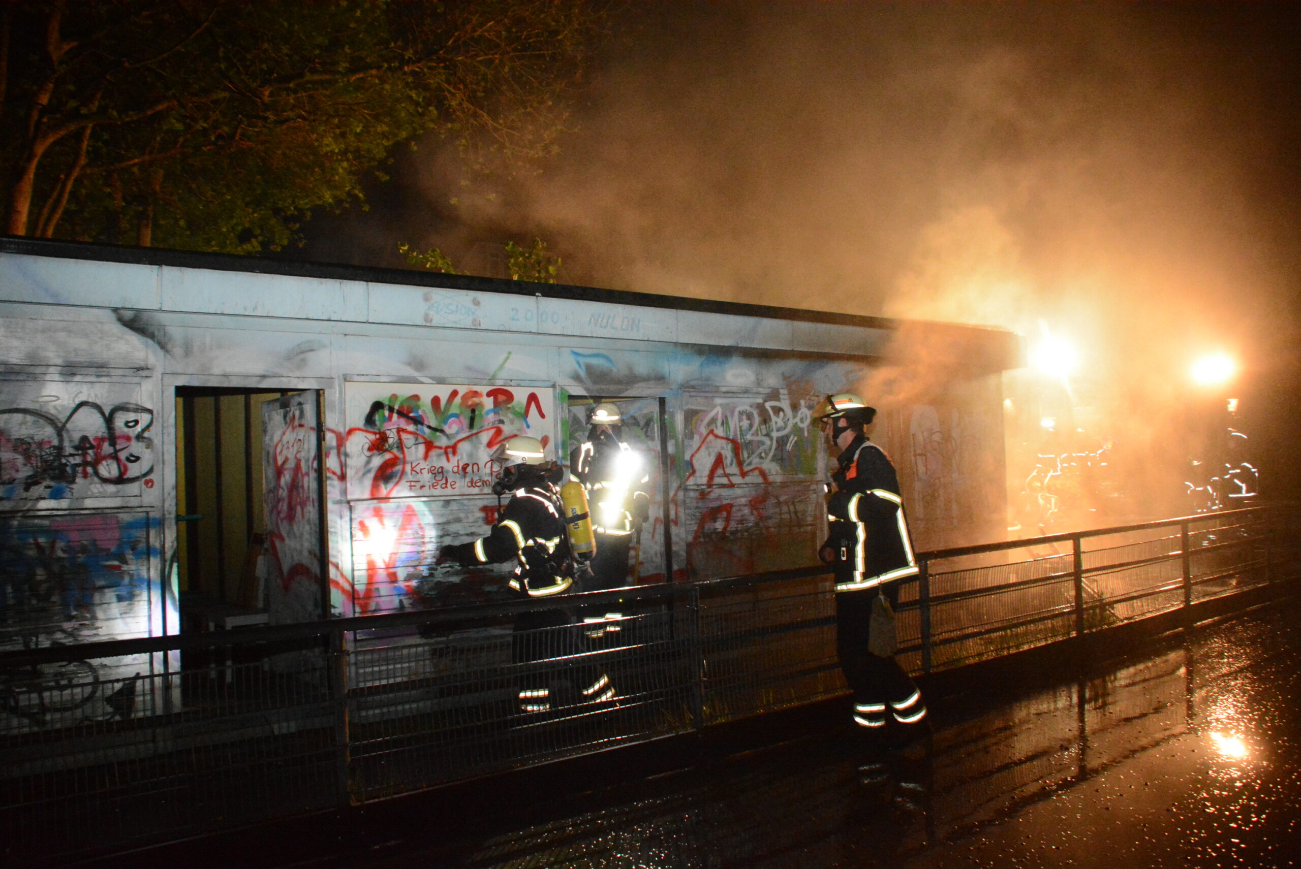 Einsatzkräfte der Feuerwehr löschen ein brennendes Holzhaus in Bergedorf.