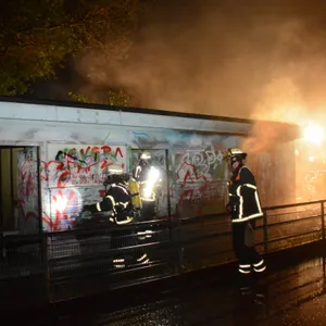 Einsatzkräfte der Feuerwehr löschen ein brennendes Holzhaus in Bergedorf.
