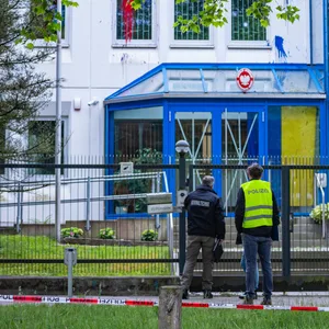 Polizeibeamte vor dem mit Farbe beschmierten Konsulat.