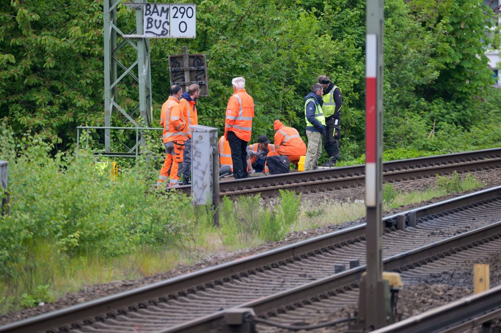 Arbeiter der Deutschen Bahn (DB) arbeiten nahe dem S-Bahnhof Sternschanze am Brandort an den Gleisen.