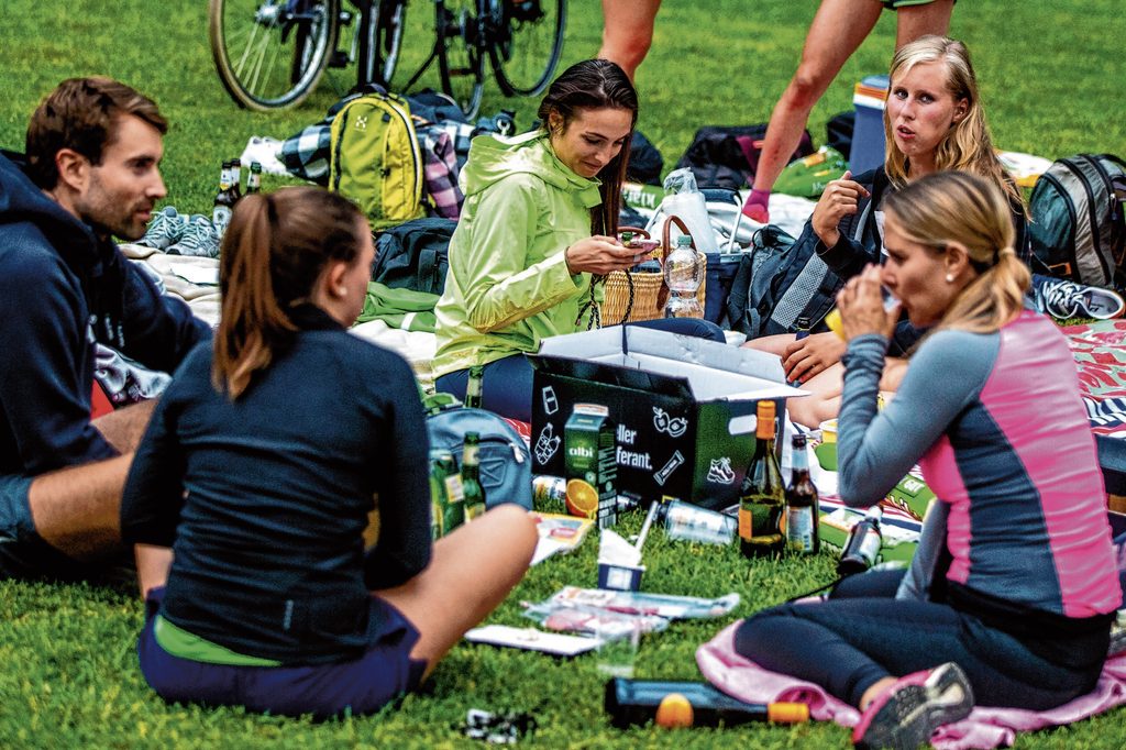 Ein Staffel-Team sitzt beim gemeinsamen Picknick im Gras.