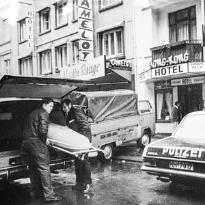Leichenbestatter verladen Sarg vor Hotel