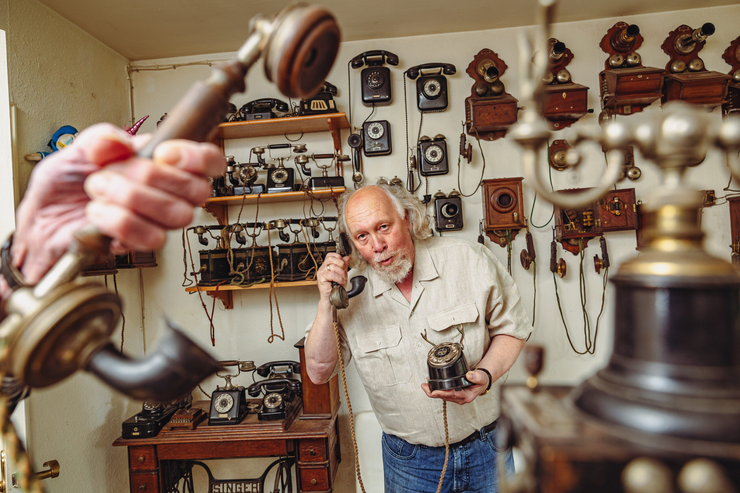 Mann vor Sammlung alter Telefone