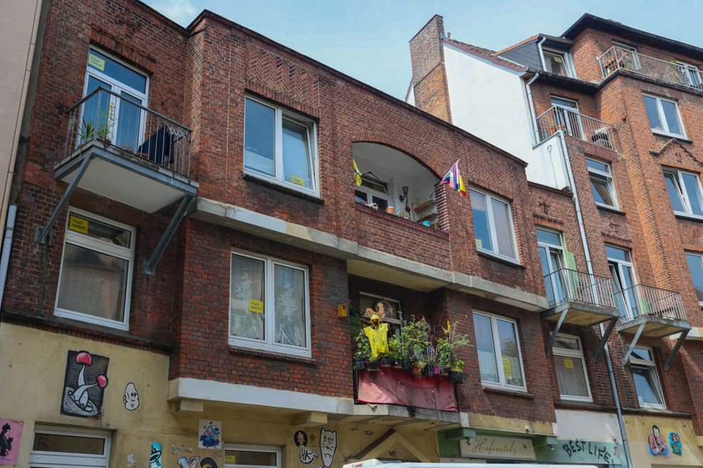 Lärm-Ärger in der Paul-Roosen-Straße. In den Fenstern hängen gelbe Schilder mit der Aufschrift „Pauli wohnt!“.