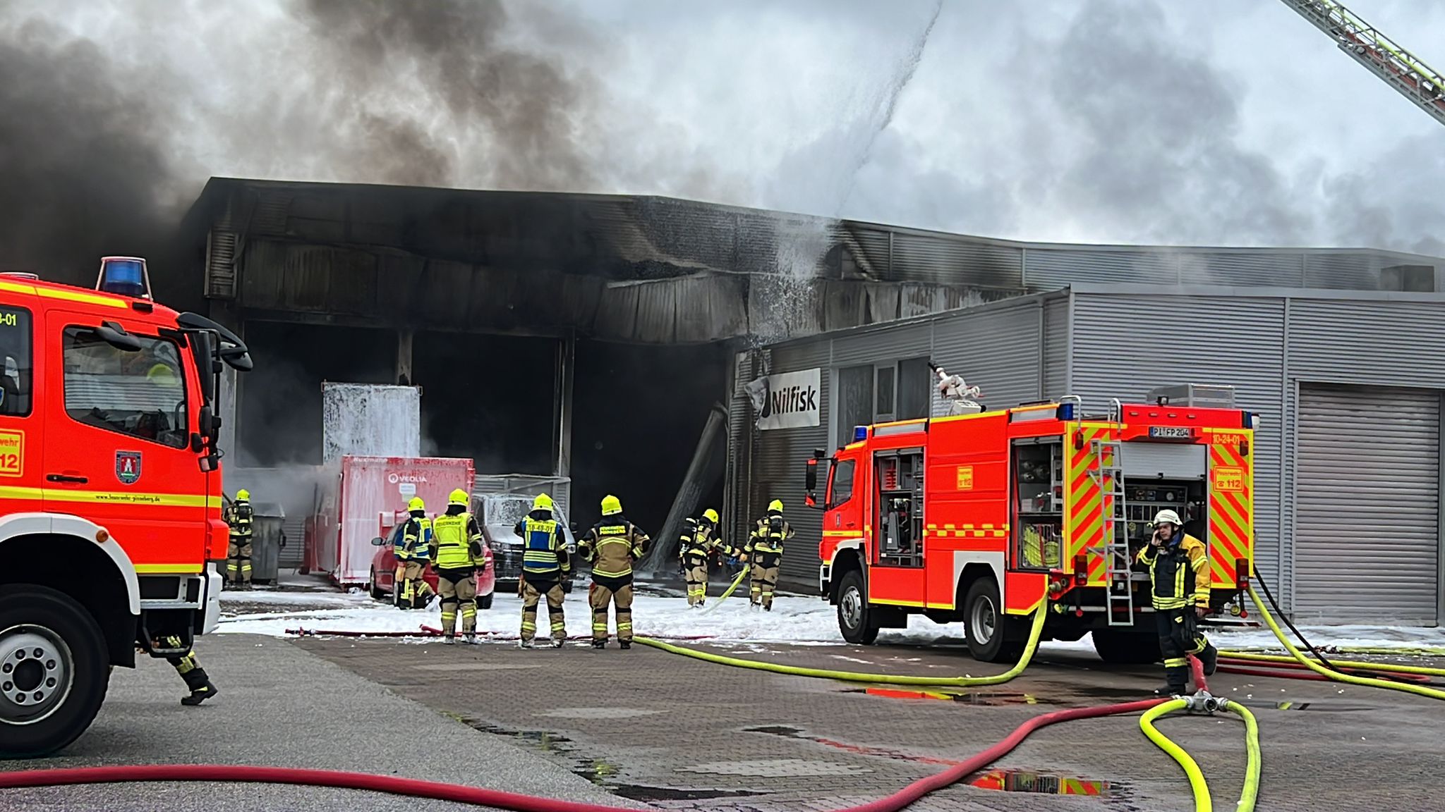 Feuerwehrleute löschen den Brand in einer Halle in Pinneberg.