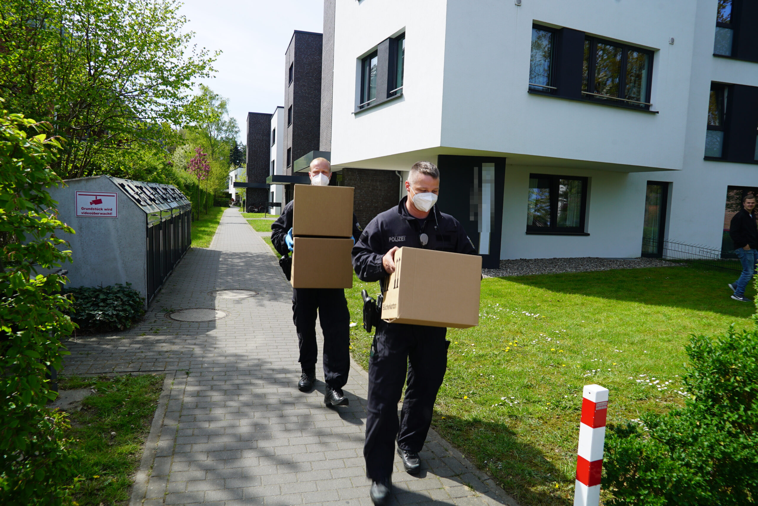 Bundespolizisten schleppen Kisten mit mutmaßlichen Beweismitteln.