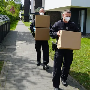 Bundespolizisten schleppen Kisten mit mutmaßlichen Beweismitteln.