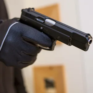 Ein Mann zielt mit einer Schusswaffe/Pistole,