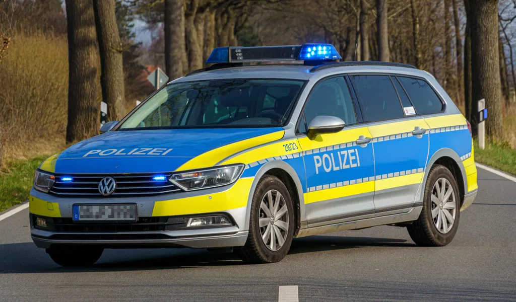 Ein 64-jähriger Radfahrer kam bei einem Unfall in Goslar ums Leben. Symbolbild: ein Einsatzfahrzeug der Polizei steht mit Blaulicht und Schriftzug auf einer Straße.