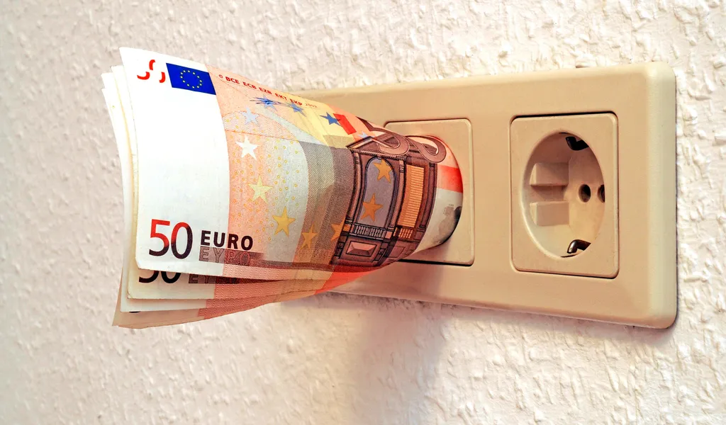 Die Energiepreise steigen und steigen. Für Anbieter gelten dennoch gewisse Regeln, mahnt die Verbraucherzentrale Hamburg. (Symbolbild): 50-Euro-Scheine stecken in einer Steckdose