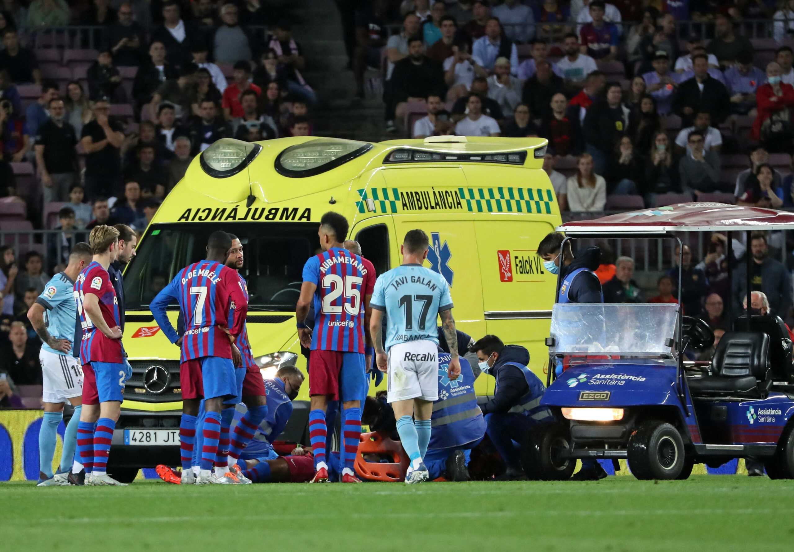 Krankenwagen auf dem Spielfeld, im Vordergrund Spieler vom FC Barcelona und Celta Vigo