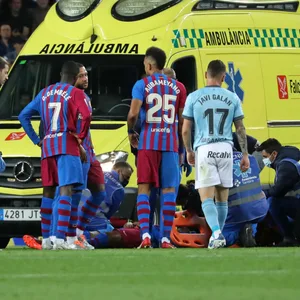 Krankenwagen auf dem Spielfeld, im Vordergrund Spieler vom FC Barcelona und Celta Vigo