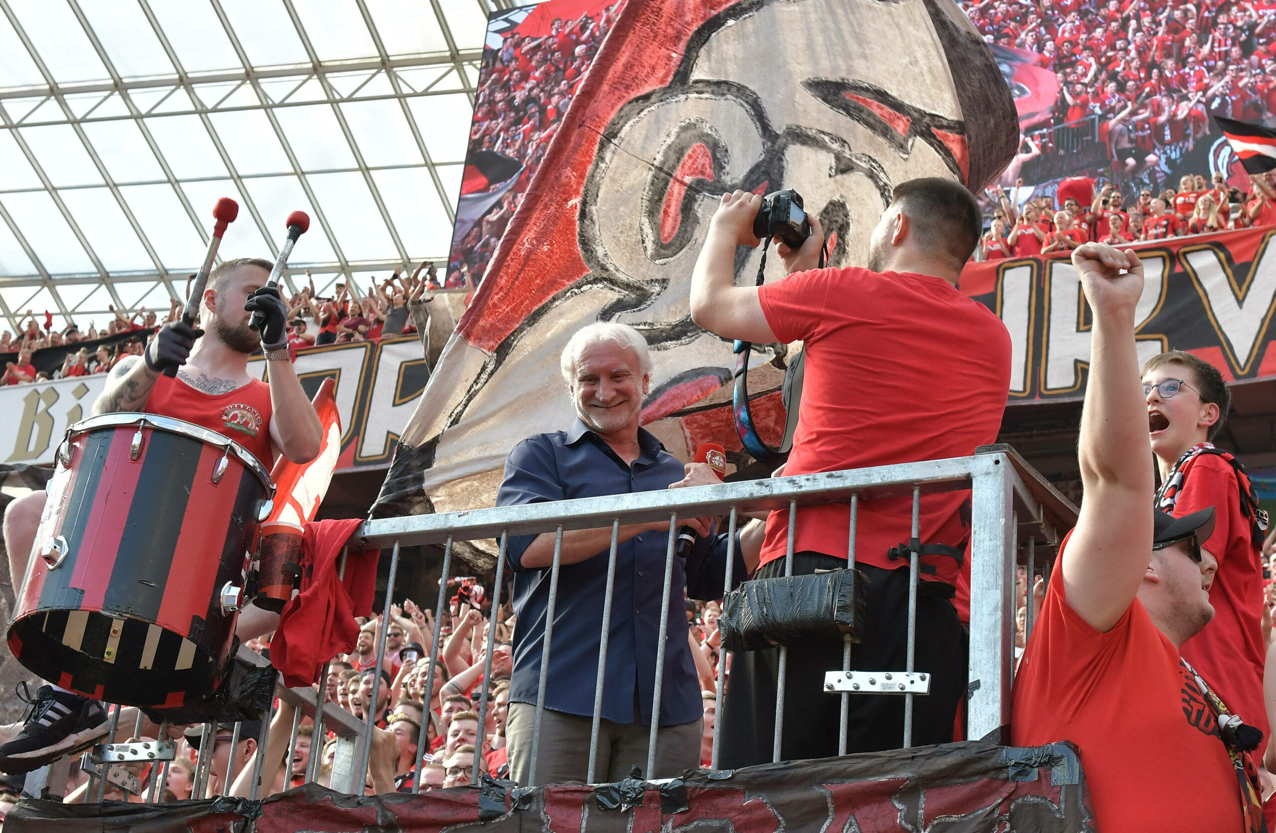 „In meiner Zeit gab es sowas noch nicht“: Rudi Völler auf dem Zaun bei den Leverkusenern Fans.