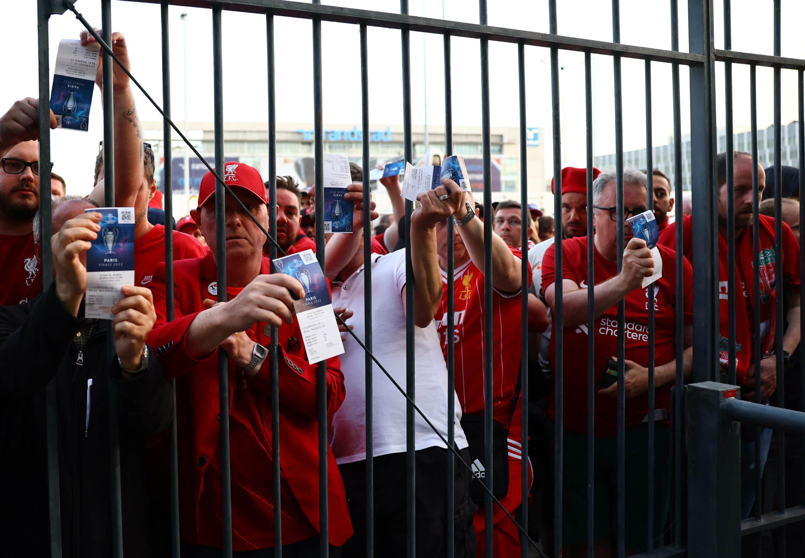 Fans des FC Liverpool zeigen ihre Eintrittskarten durch ein Gitter