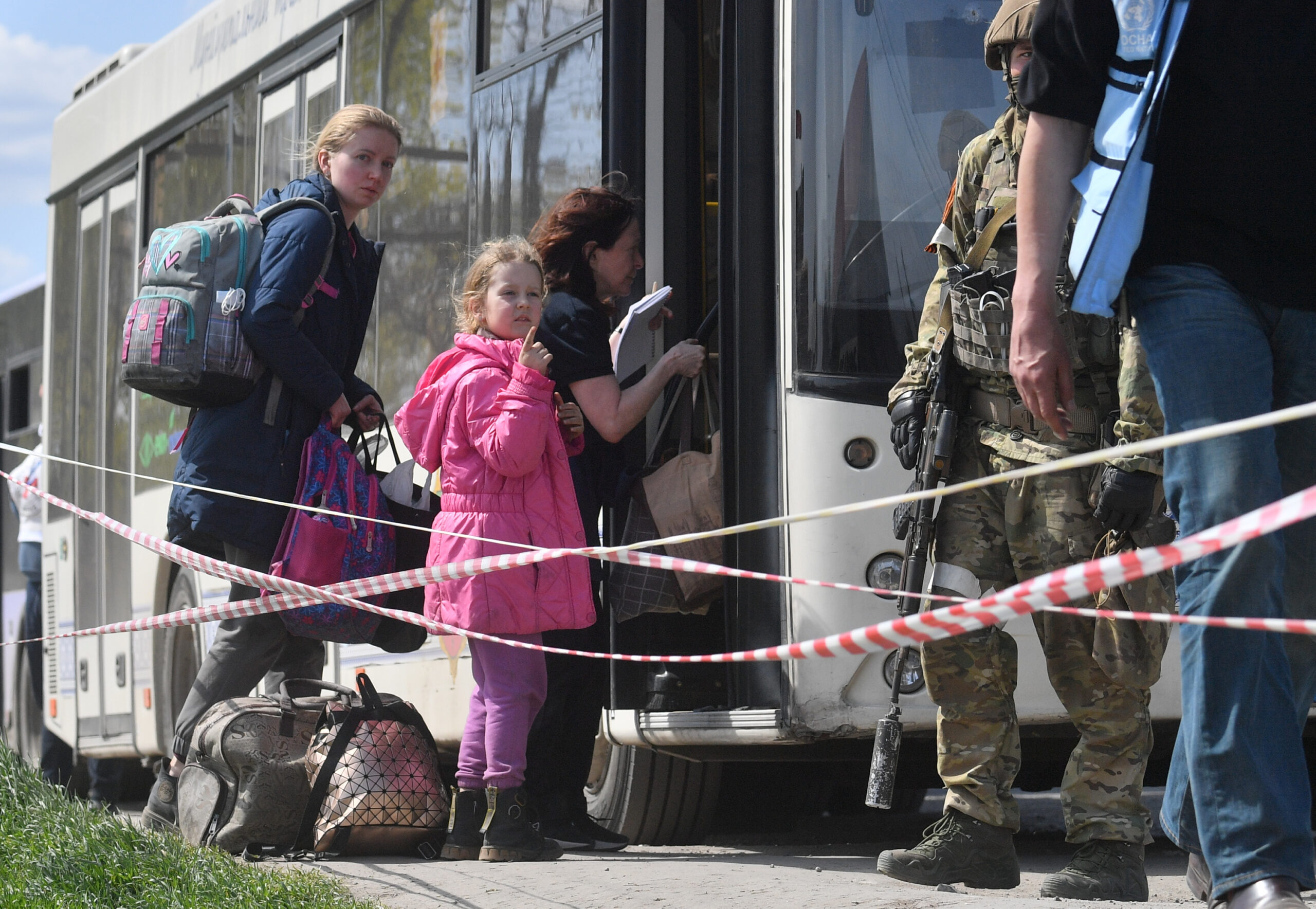 Ukrainische Zivilsten werden aus Mariupol gebracht – bewacht von russischen Soldaten. Nicht alle sind freiwillig gegangen.