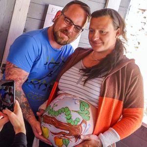 Die Hobbymalerin Marienn Pyko aus Wismar fotografiert die werdenden Eltern Matthias und Sandra Genz mit dem bemalten Babybauch.
