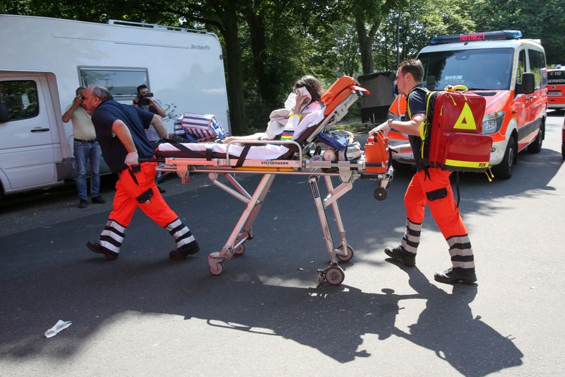Rettungssanitäter bringen eine Schülerin zu einem Rettungswagen.