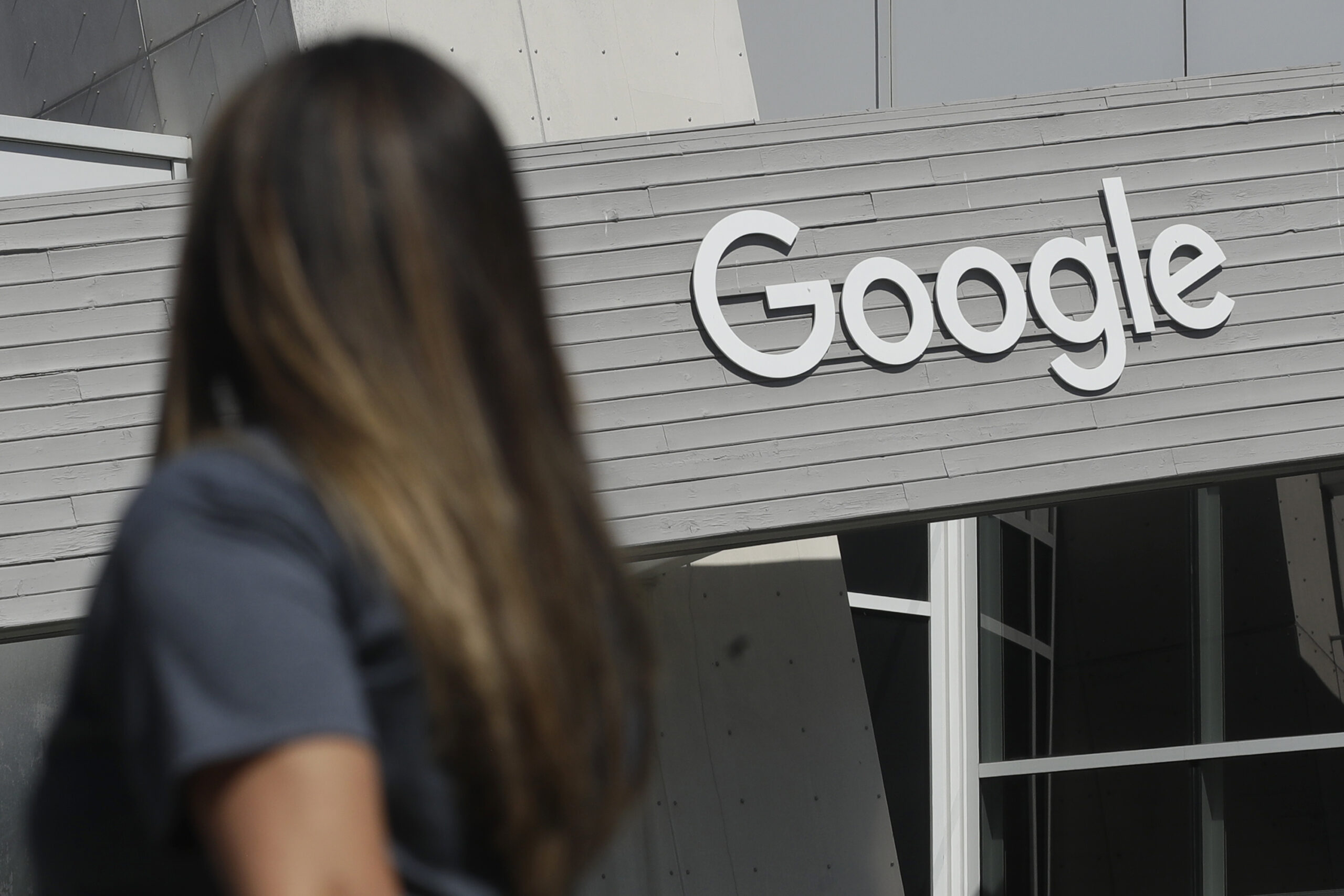 Eine Frau steht vor einem Bürogebäude von Google.
