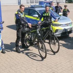 Polizeibeamte stellen die neuen E-Fahrzeuge vor.