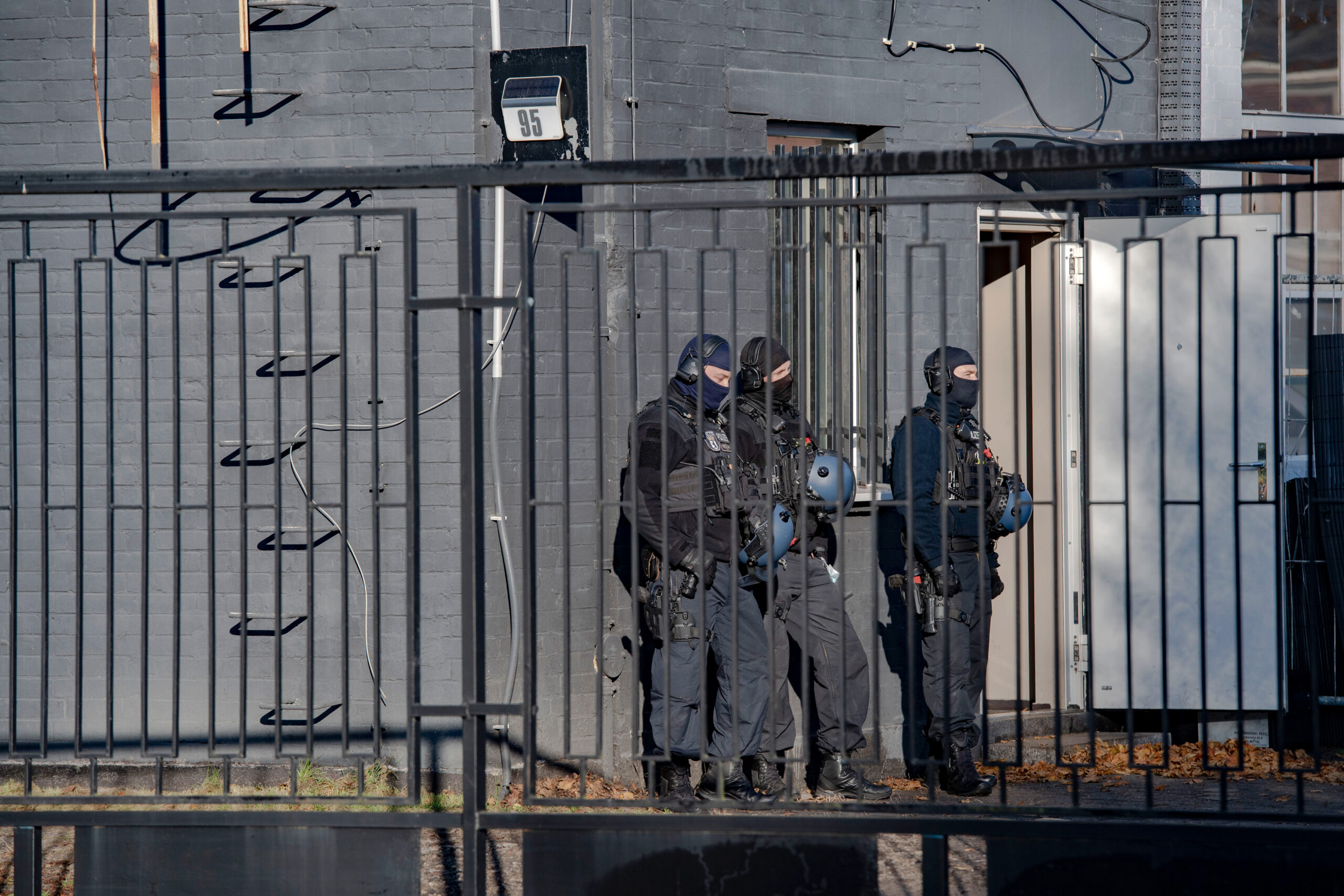 Polizeibeamte stehen vor einem Gebäude in einem Gewerbegebiet in Weißensee.