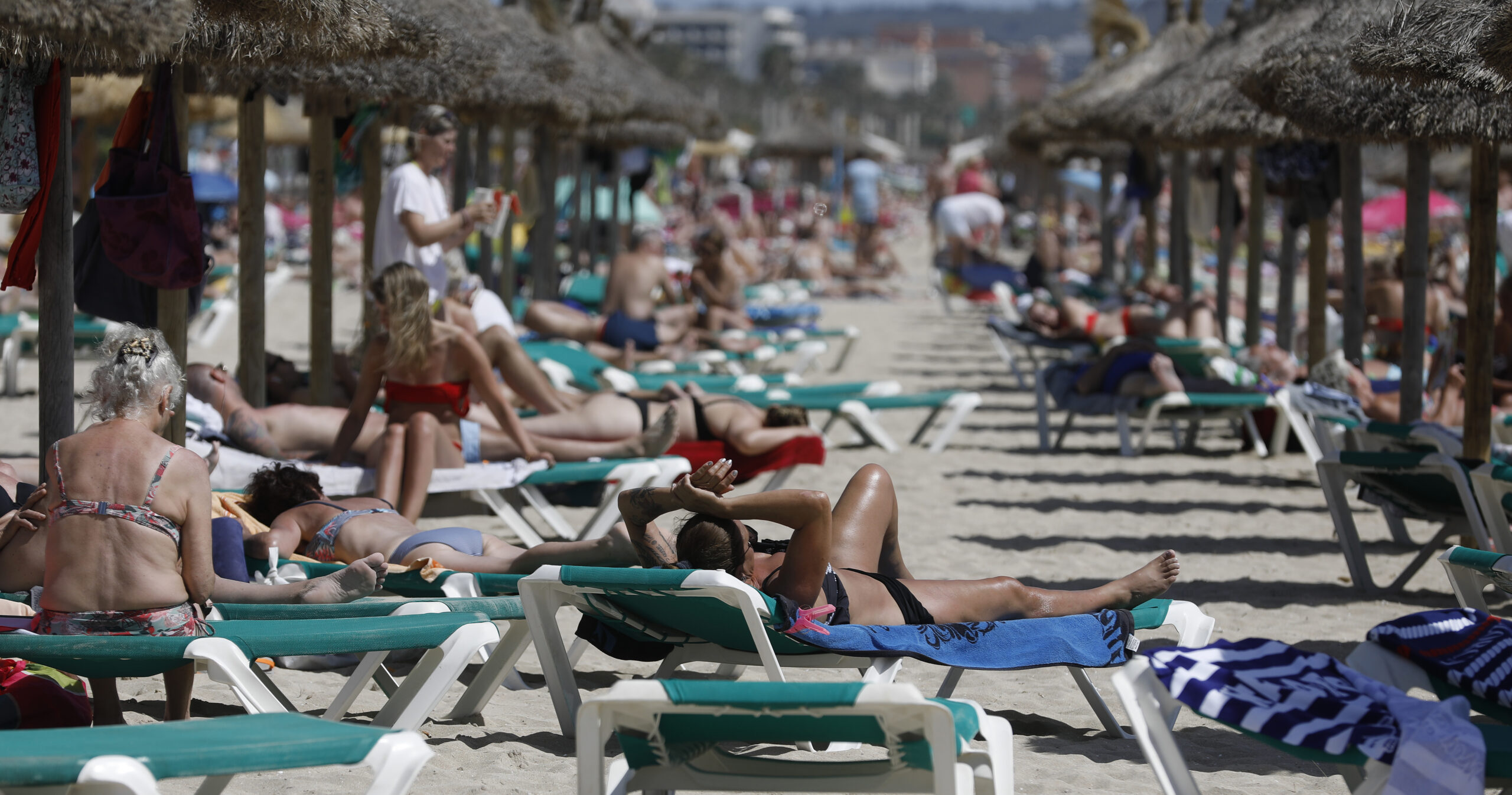 Menschen sonnen sich am Strand von Arenal.