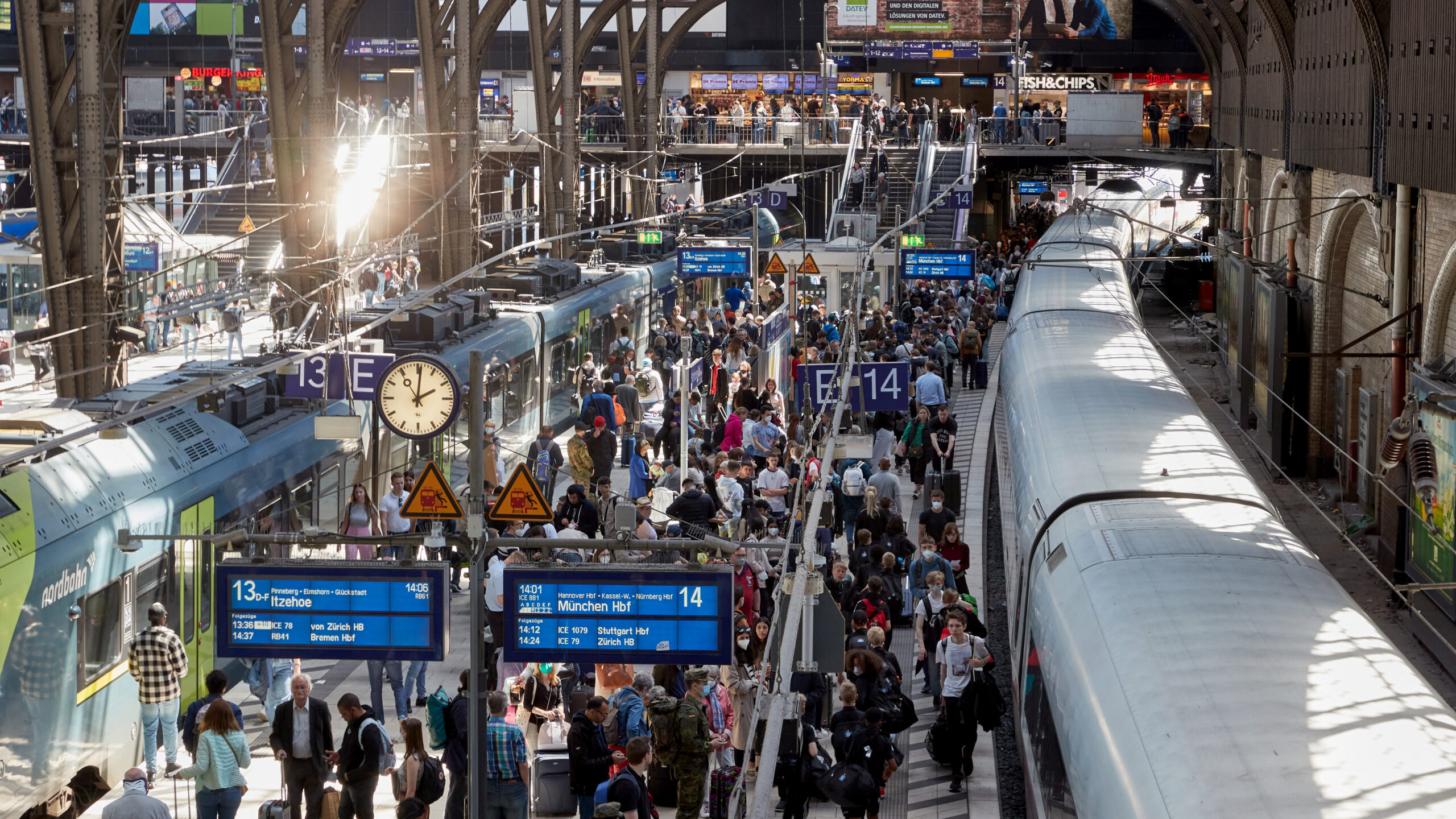 Viele Reisende stehen auf dem Bahnsteigen 13 und 14 im Hauptbahnhof, von denen sowohl IC, ICE Züge im Fernverkehr als auch Regionalbahnen abfahren.