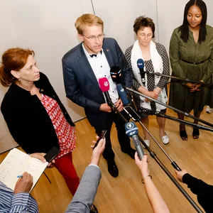 Die Politiker:innen stehen vor Journalist:innen und beantworten Fragen.