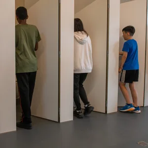 Jungen und Mädchen gehen in eine Unisextoilette