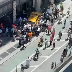 Menschen helfen Fußgängern, die in New York von einem Taxi angefahren wurden.