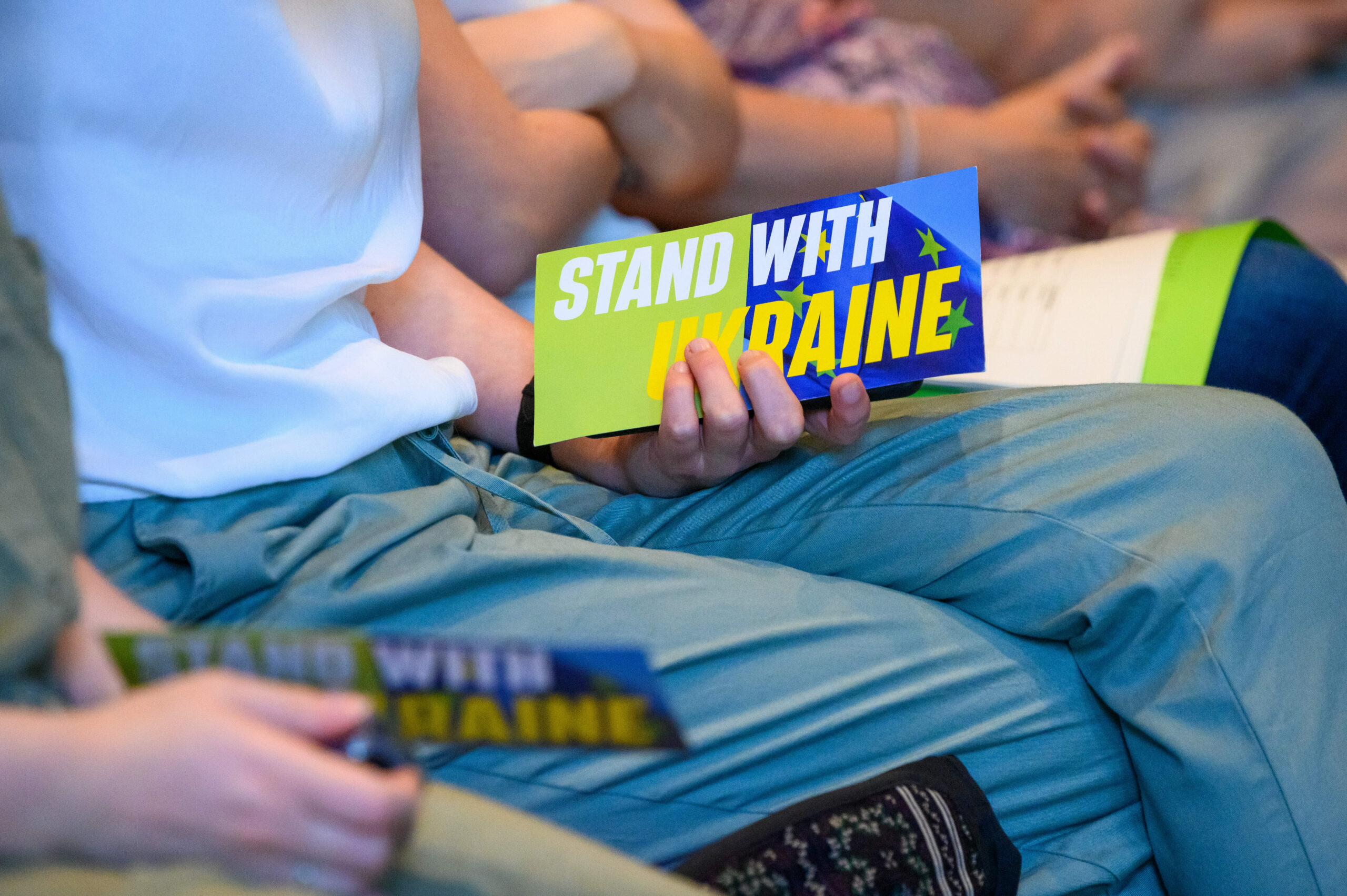 Eine Frau hält eine Abstimmungskarte mit der Aufschrift „Stand with Ukraine“ während der Landesmitgliederversammlung der Hamburger Grünen.