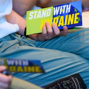 Eine Frau hält eine Abstimmungskarte mit der Aufschrift „Stand with Ukraine“ während der Landesmitgliederversammlung der Hamburger Grünen.
