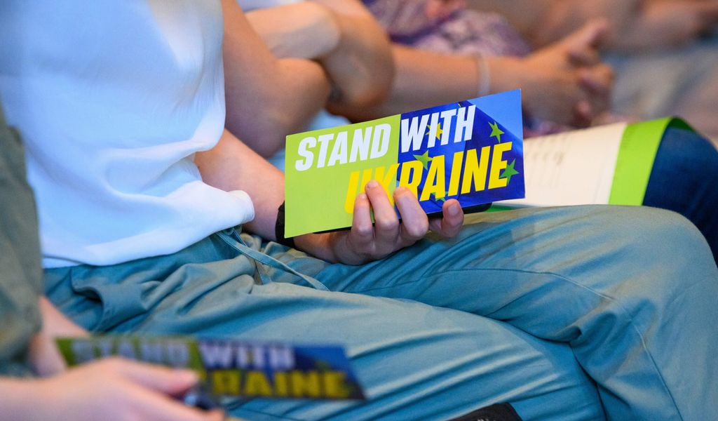 Eine Frau hält eine Abstimmungskarte mit der Aufschrift „Stand with Ukraine“ während der Landesmitgliederversammlung der Hamburger Grünen.