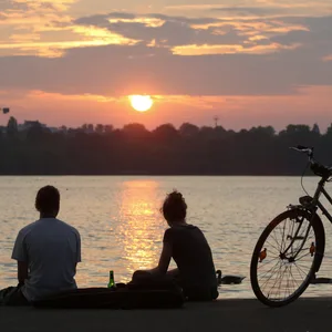 Menschen setzten an der Außenalster und blicken auf den Sonnenuntergang