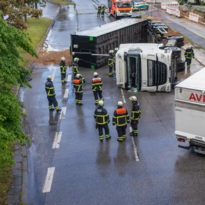 Feuerwehrkräfte vor dem umgekippten Laster.