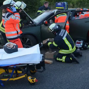 Mehrere Rettungskräfte stehen neben einem Auto