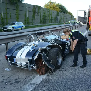 Eine Polizistin begutachtet den schwer beschädigten Oldtimer.