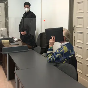 Der verurteilte Exhibitionist verdeckt sein Gesicht vor den Kameras.