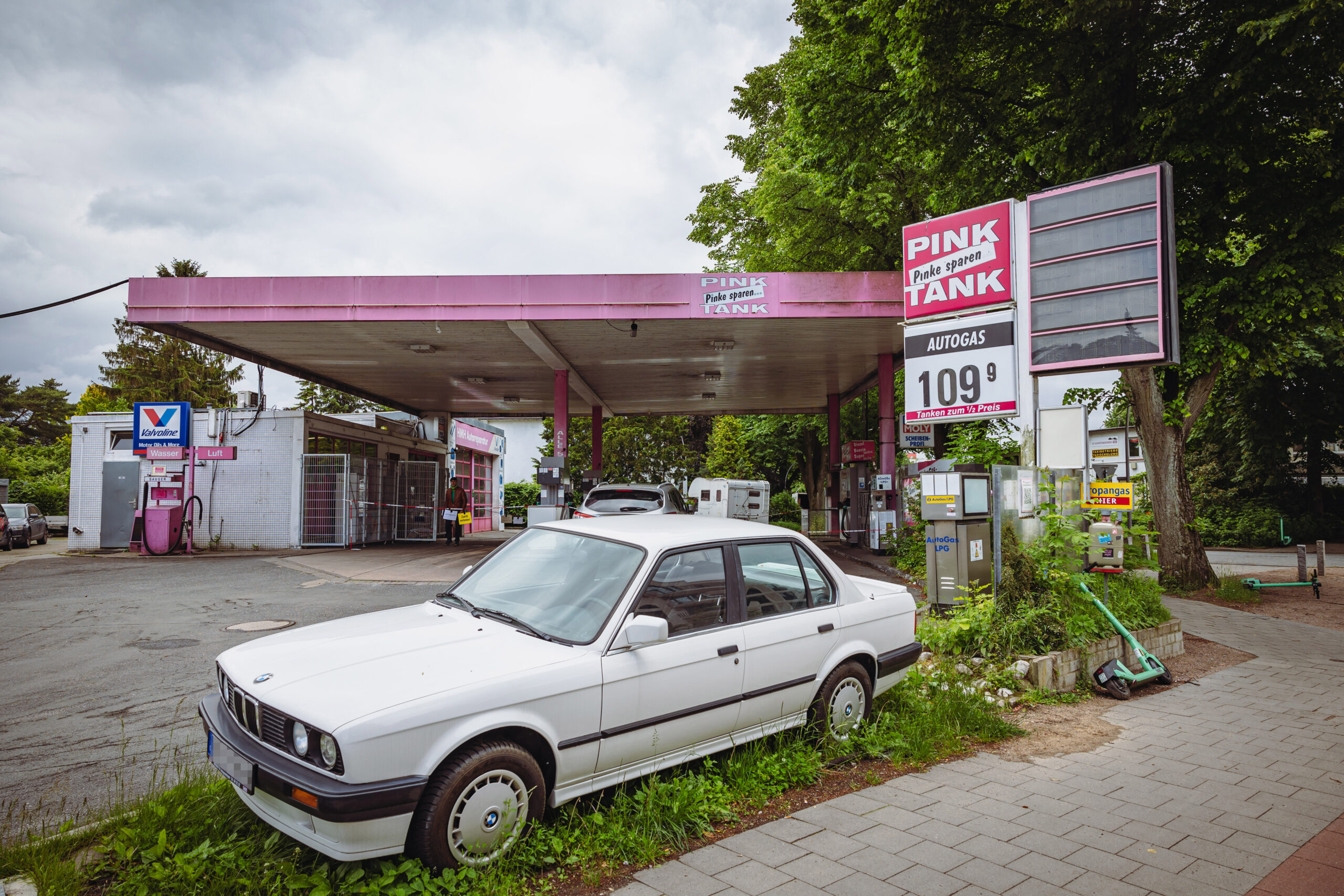 Pinkfarbene Tankstelle mit altem Auto davor