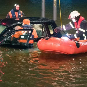 Feuerwehrleute befreien einen Mann aus seinem Auto.