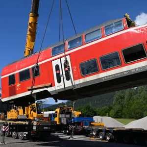 Bergungsarbeiten: Ein auseinandergeschnittenes Waggonteil wird vom Laster gehoben.