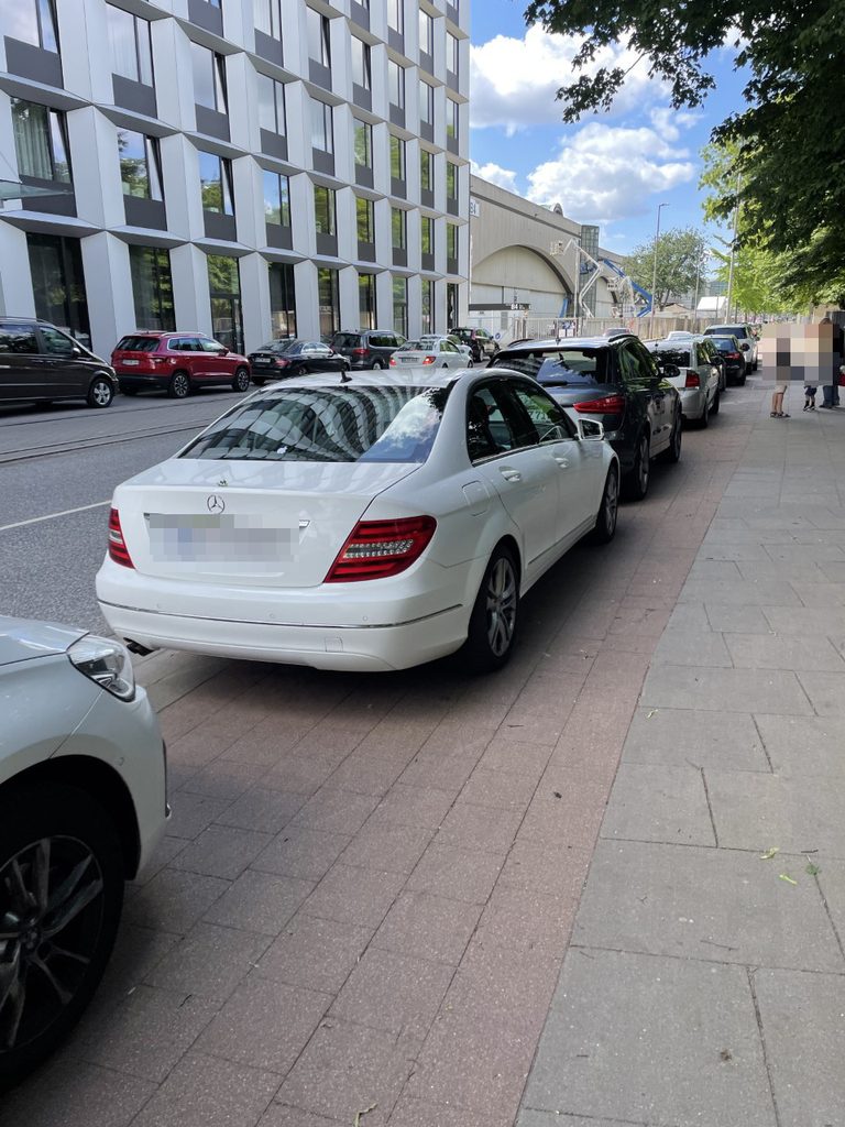 Eine Reihe parkender Autos blockiert den Radweg an den Messehallen.