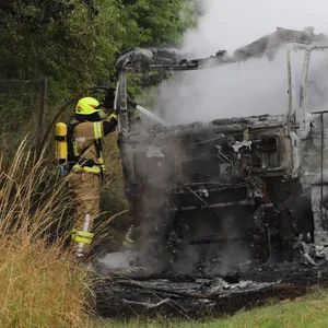 Feuerwehrkräfte am ausgebrannten Milchlaster.