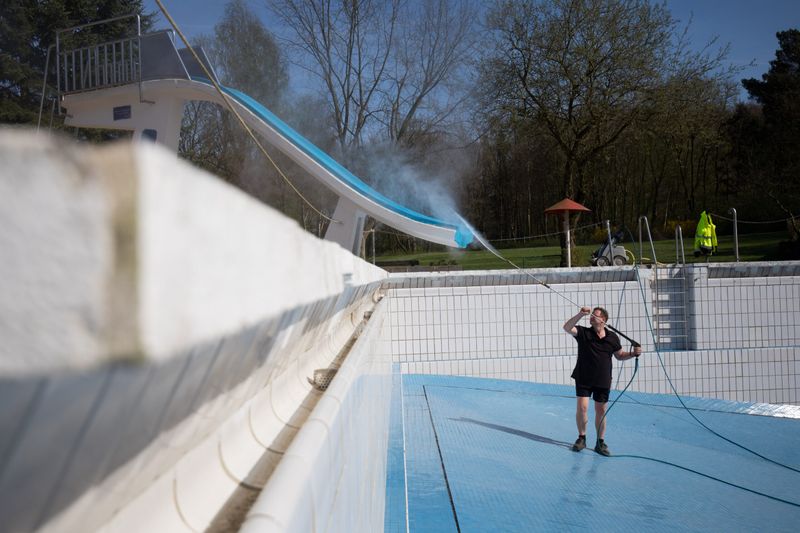 Bademeister im leeren Schwimmbecken, Reinigung