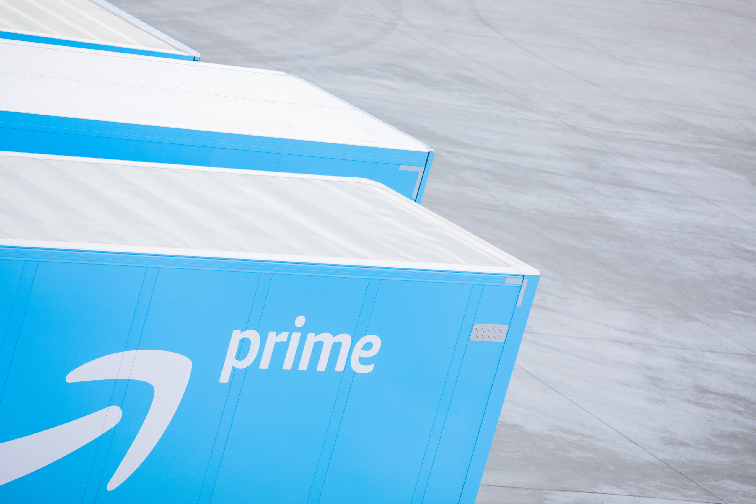 Lkw mit dem Logo von Amazon Prime stehen vor einem Logistikzentrum des Versandhändlers Amazon. (Symbolbild)