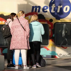 Reisende stehen im Hauptbahnhof vor einem Metronom.