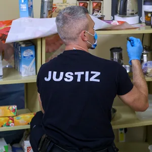 Ein Justiz-Beamter durchsucht eine Gefängniszelle.