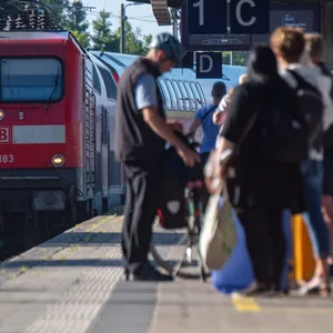 Fahrgäste warten im Bahnhof auf eine Regionalbahn. Wegen der Sommerferien waren Staus auf den Autobahnen erwartet worden, doch dort blieb es im Gegensatz zu den Zügen ruhig. (Archivbild)